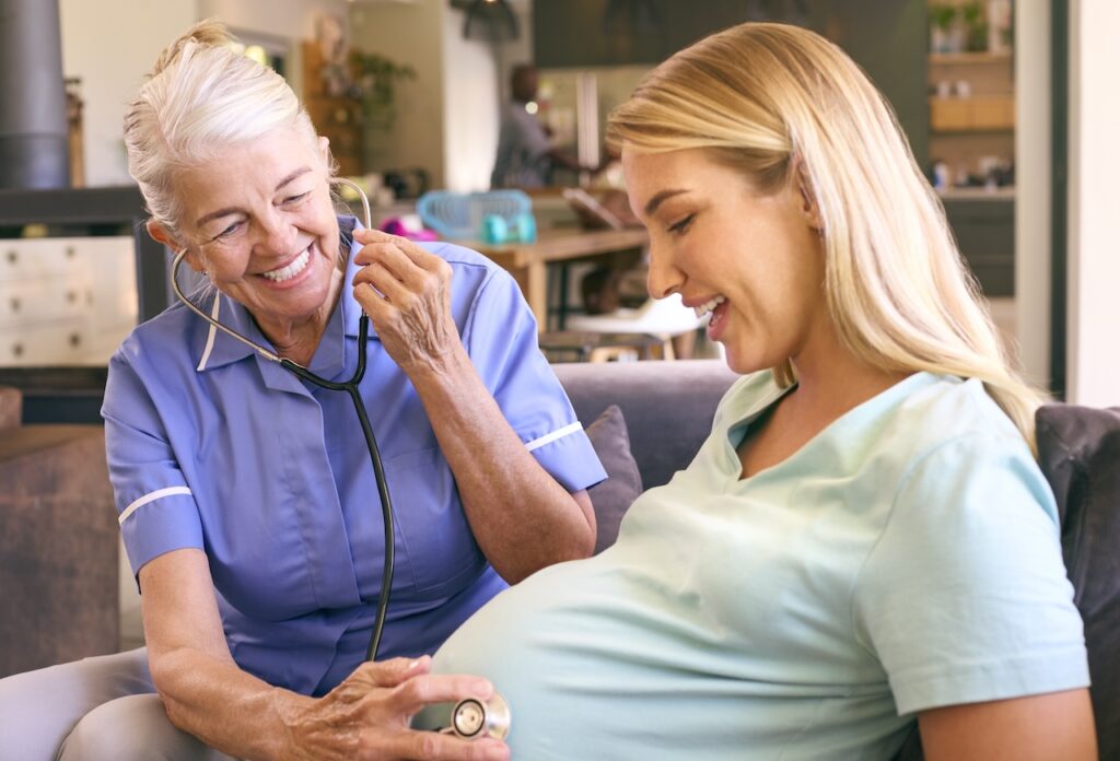 Senior midwife doing a routine check in the home of the pregnant mother.
