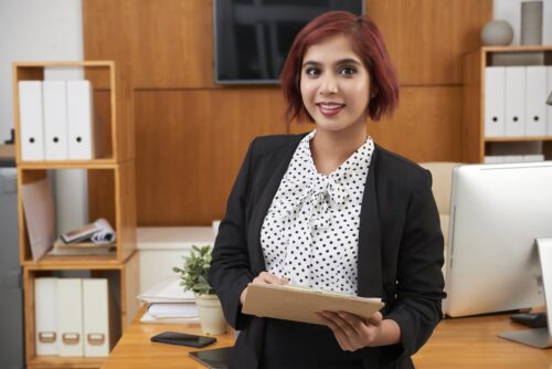 birth injury attorney holding a clipboard and smiling at the camera